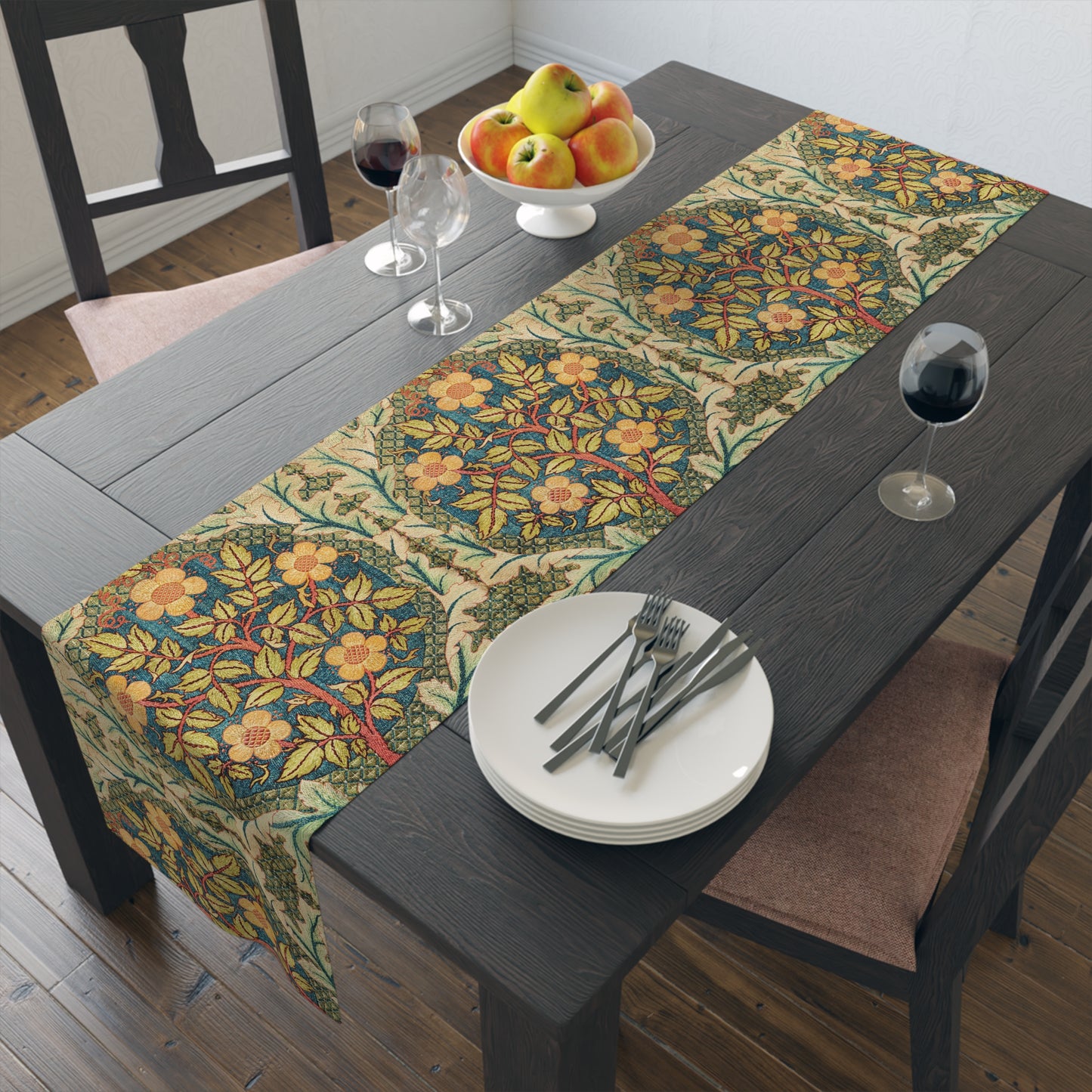 A table runner with a floral pattern inspired by William Morris, displayed on a dining table set with dishes and glasses.