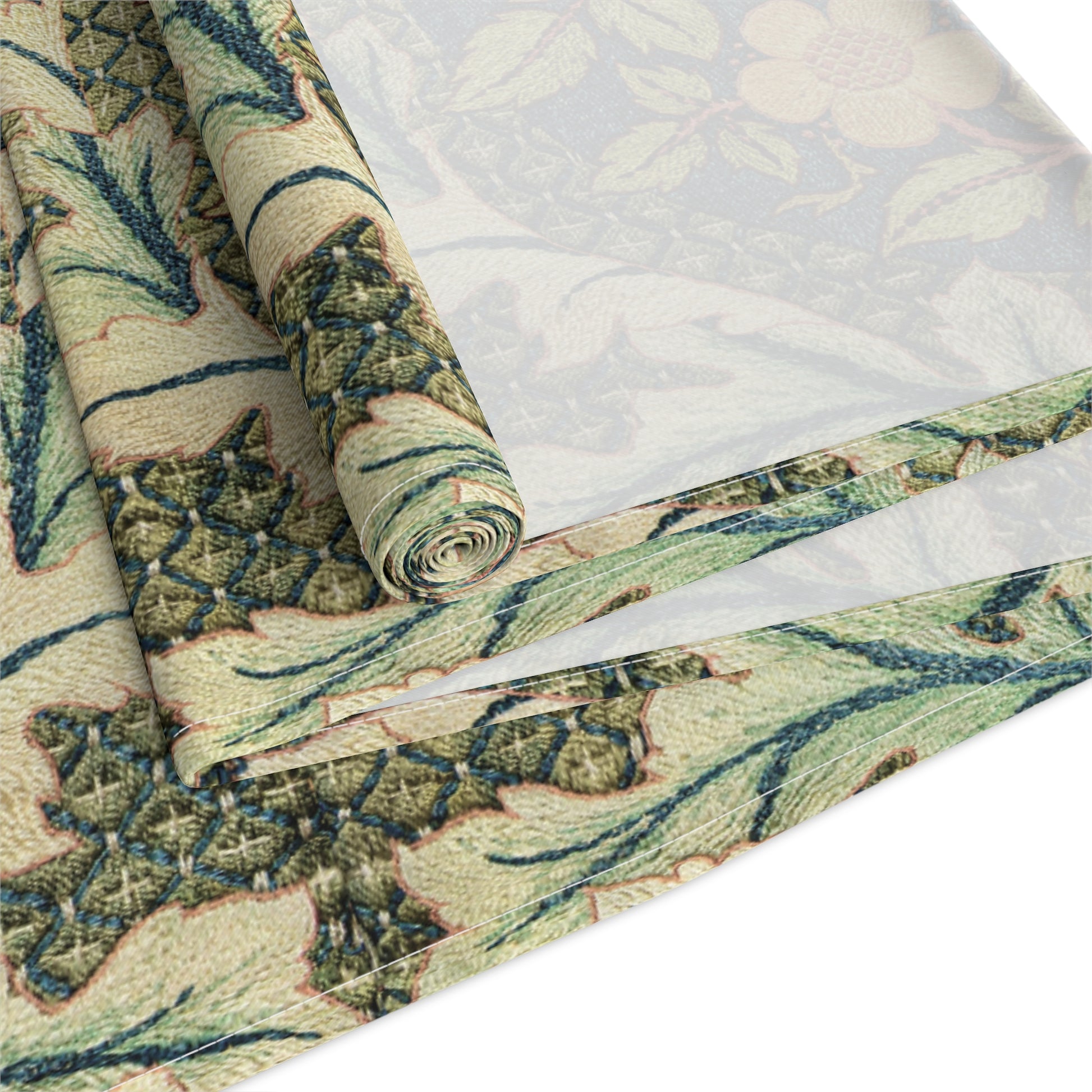 A table runner with a floral pattern inspired by William Morris, displayed on a dining table set with dishes and glasses.