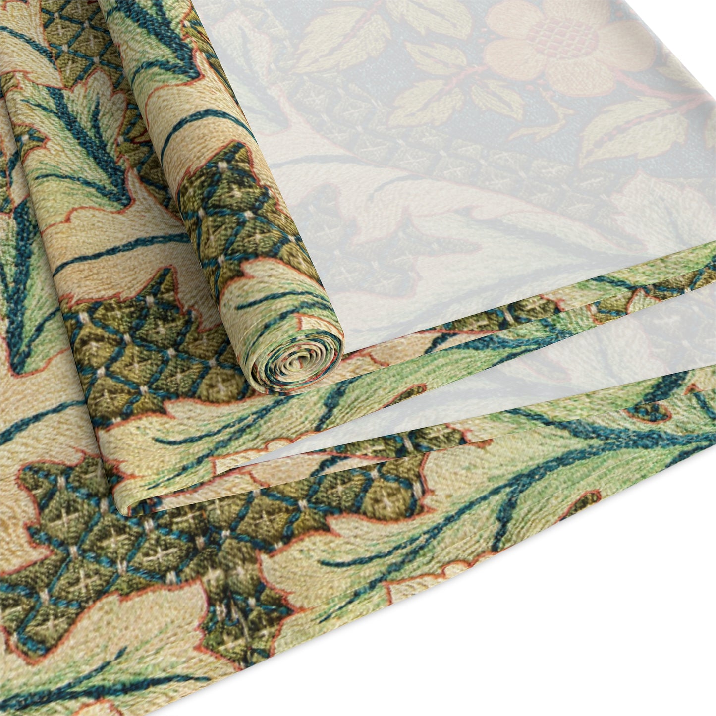 A table runner with a floral pattern inspired by William Morris, displayed on a dining table set with dishes and glasses.
