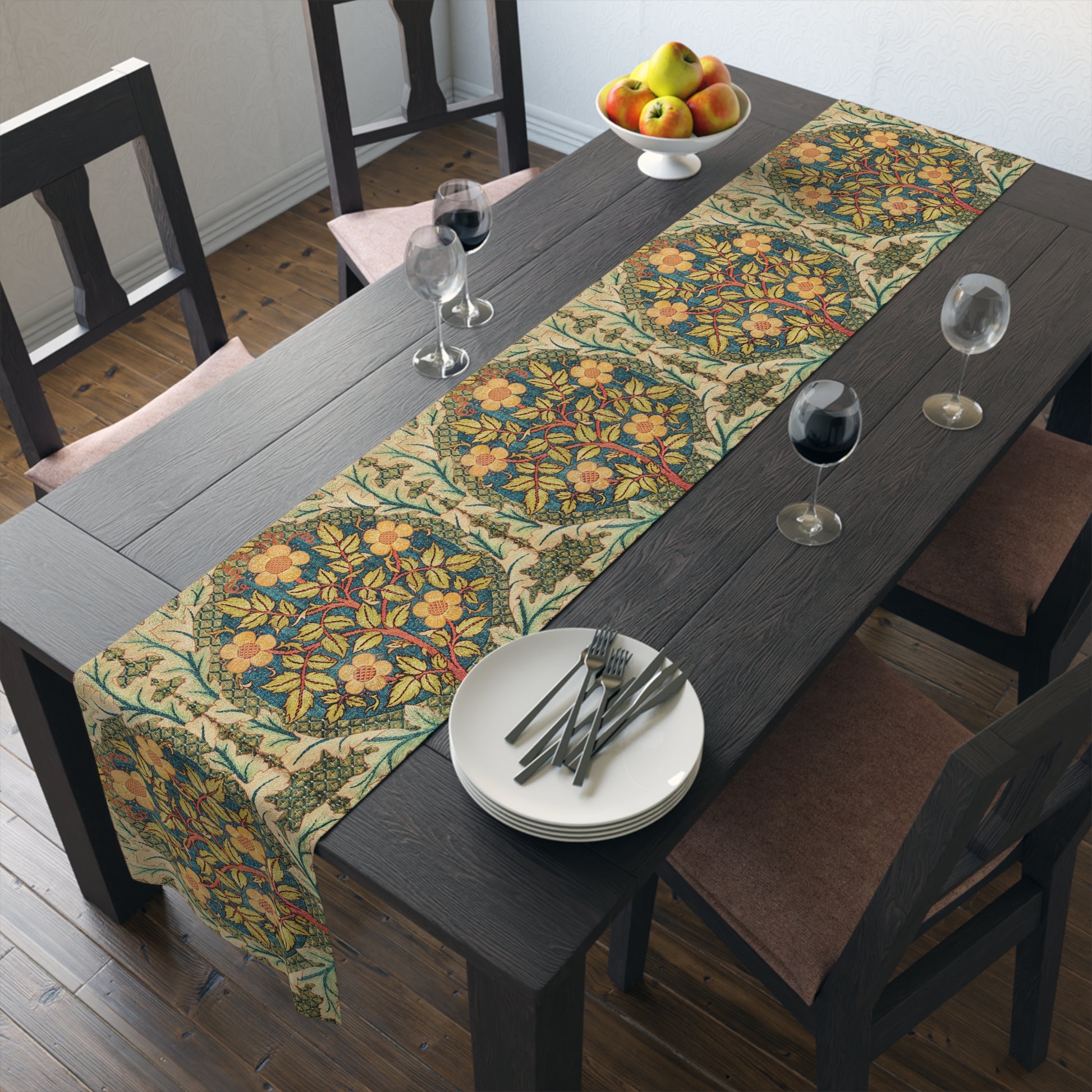 A table runner with a floral pattern inspired by William Morris, displayed on a dining table set with dishes and glasses.