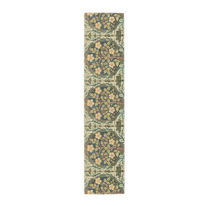 A table runner with a floral pattern inspired by William Morris, displayed on a dining table set with dishes and glasses.