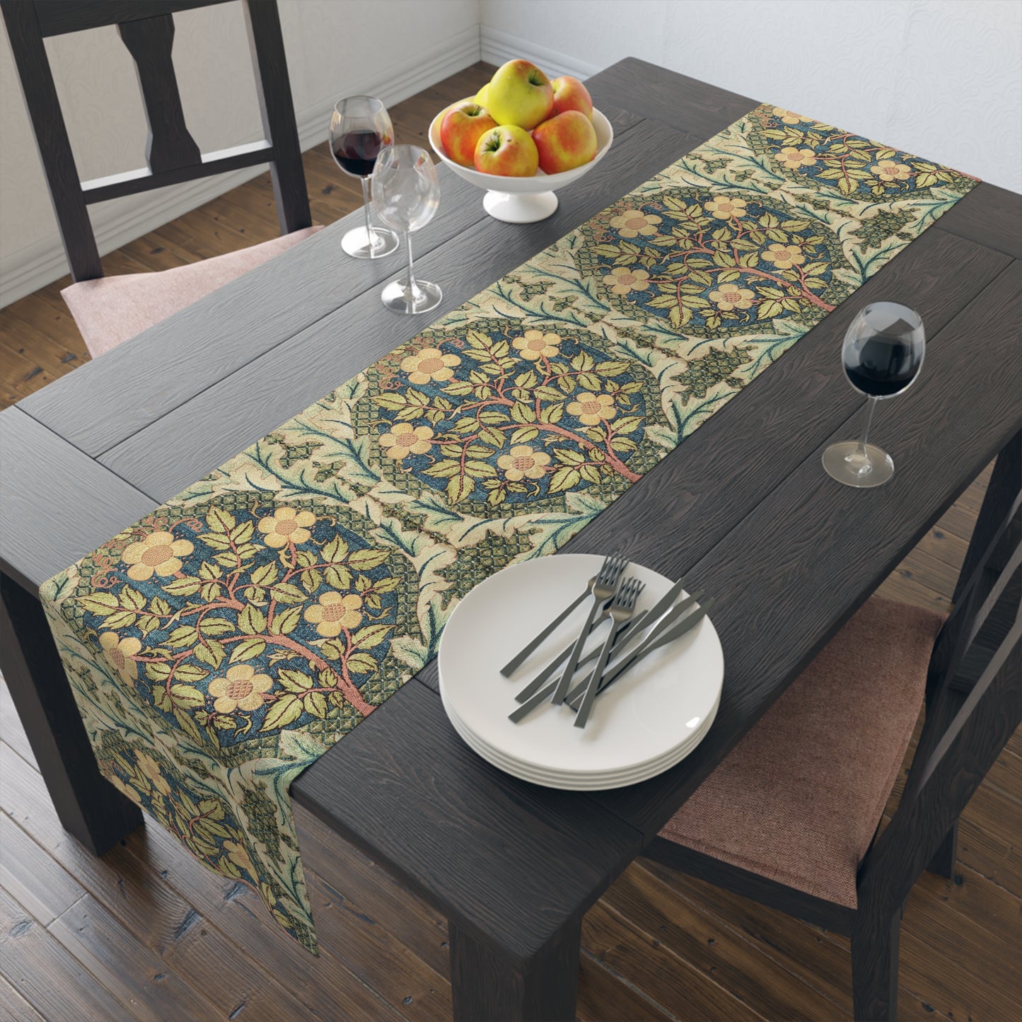 A table runner with a floral pattern inspired by William Morris, displayed on a dining table set with dishes and glasses.