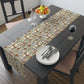 Dining table with floral-patterned table runner, plates, forks, and a bowl of fruit.