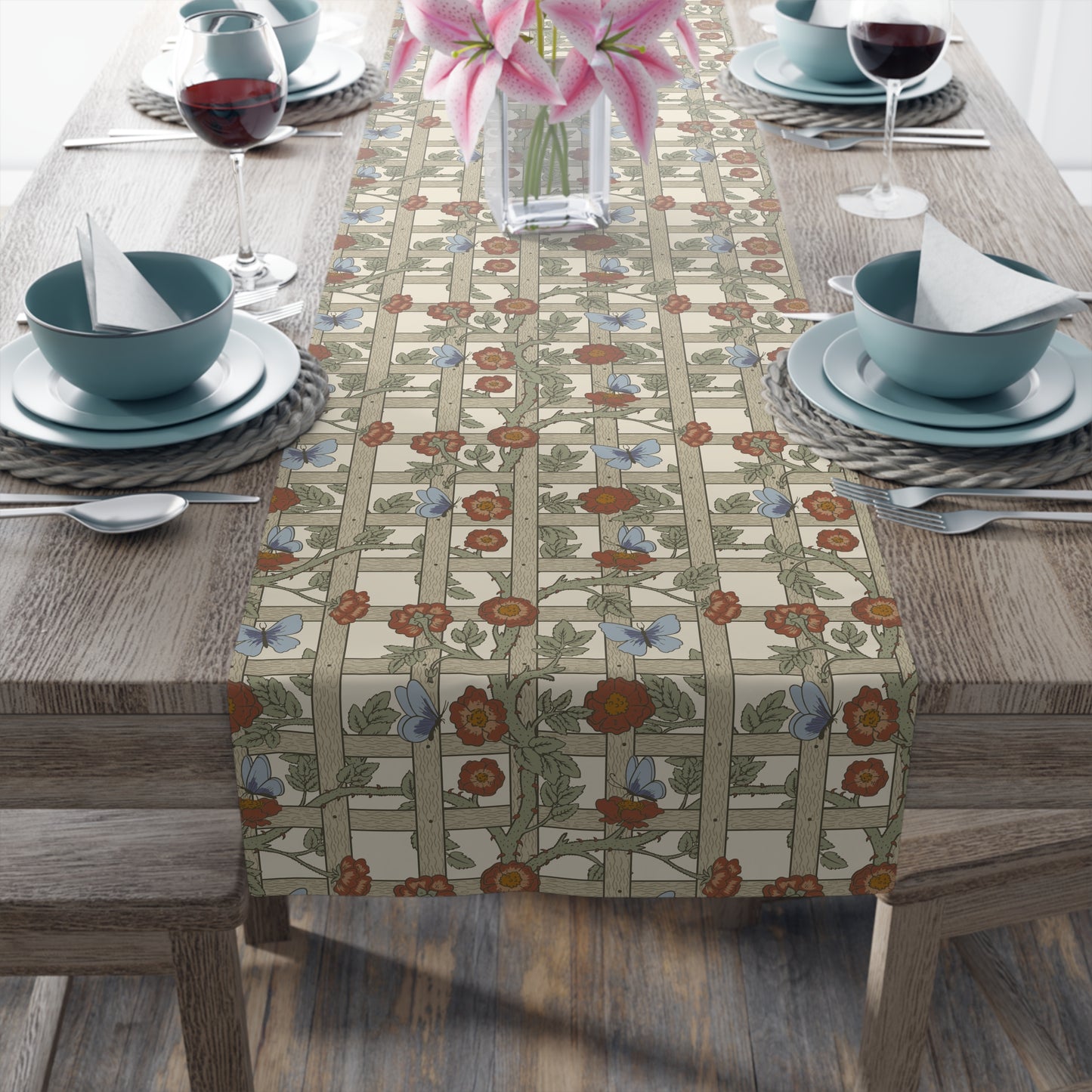 Table setting with a floral table runner on a wooden table.