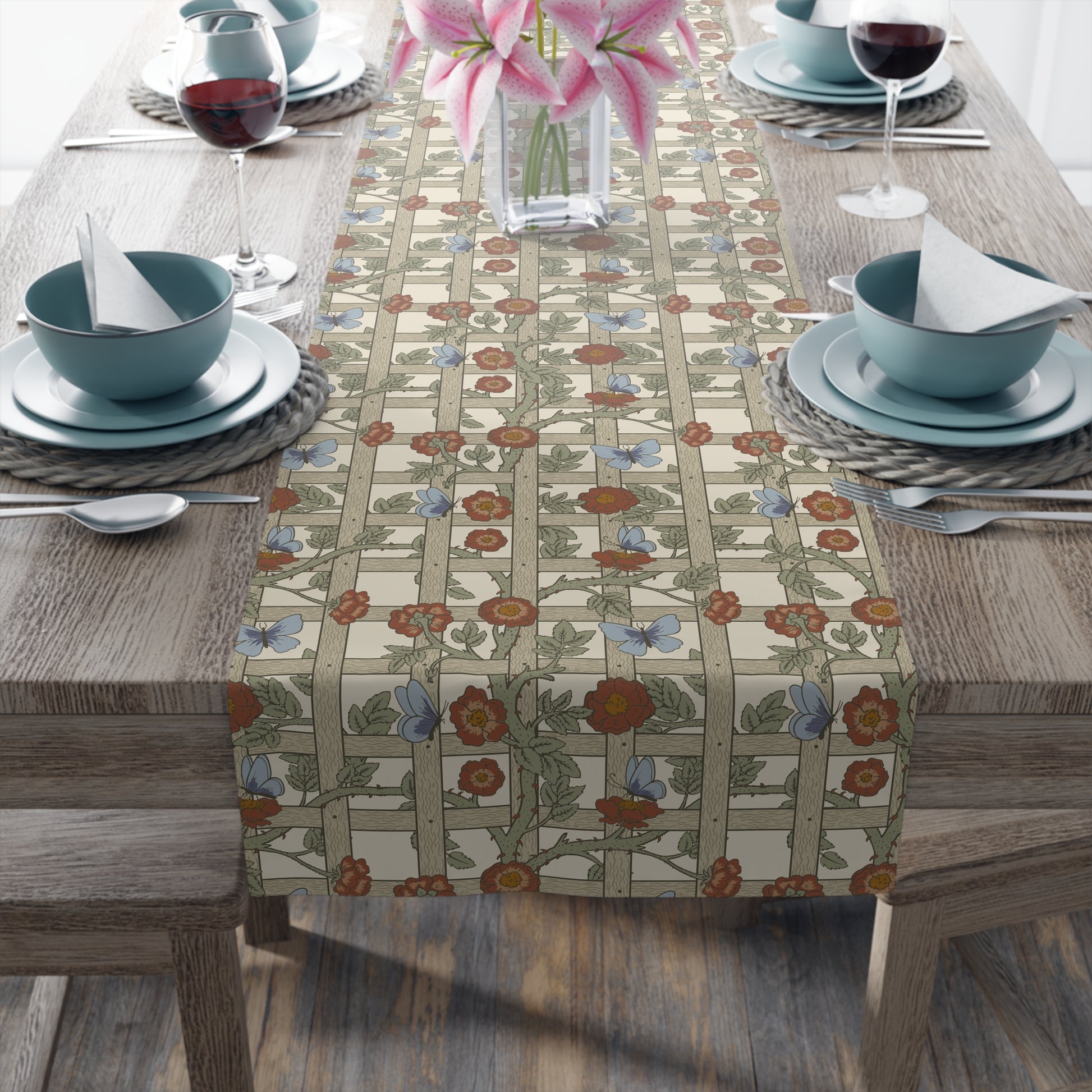 Table setting with a floral table runner on a wooden table.