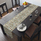 Dining table with a patterned table runner, plates, and glasses in a room.