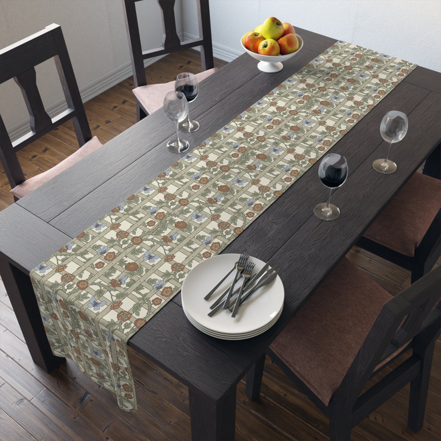 Dining table with a patterned table runner, plates, and glasses in a room.