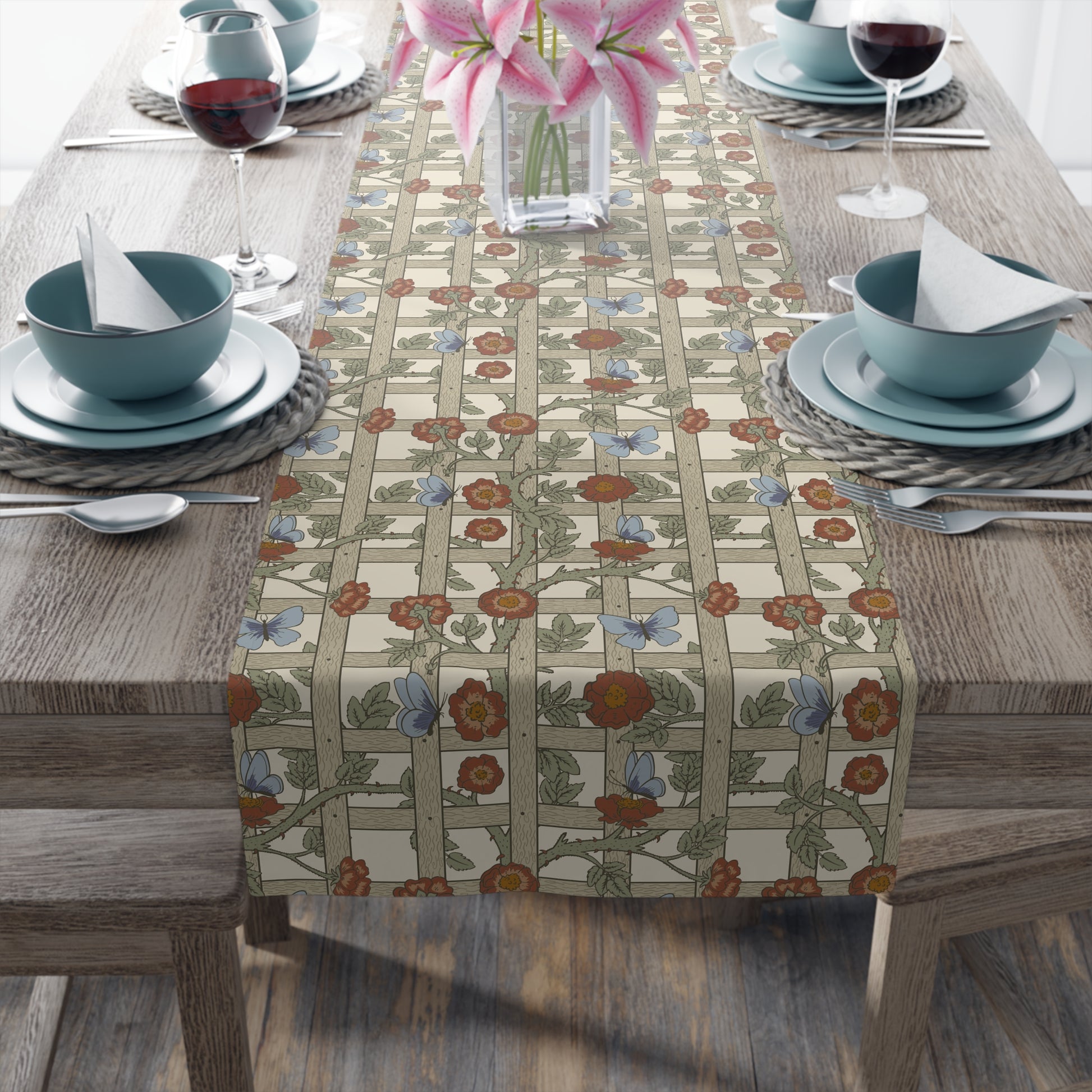 Table setting with a floral table runner on a wooden table.