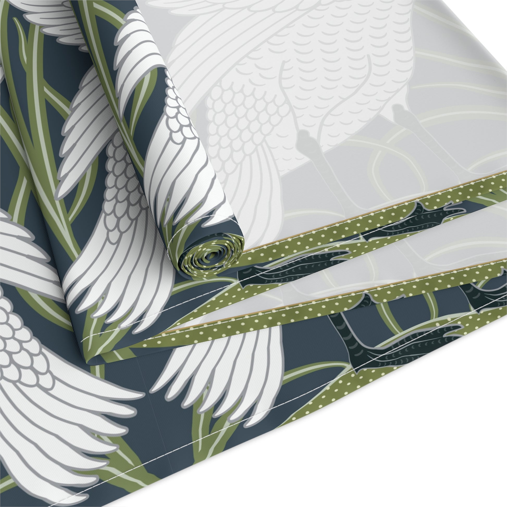 Roll of fabric with a pattern of white feathers, green leaves, and blue accents on a white background.