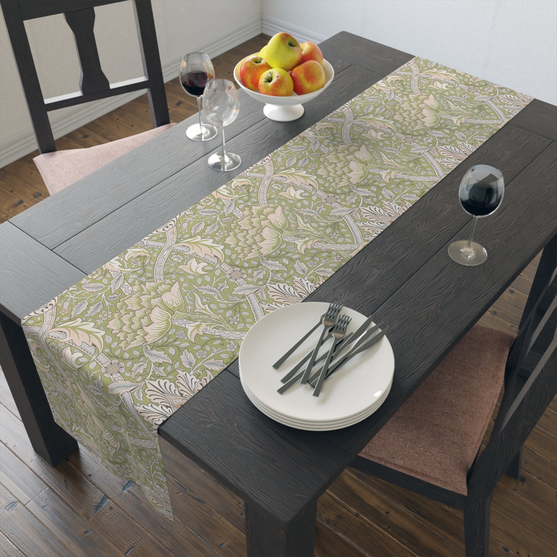 Dining table with a floral-patterned table runner, plates, cutlery, and fruit bowl.