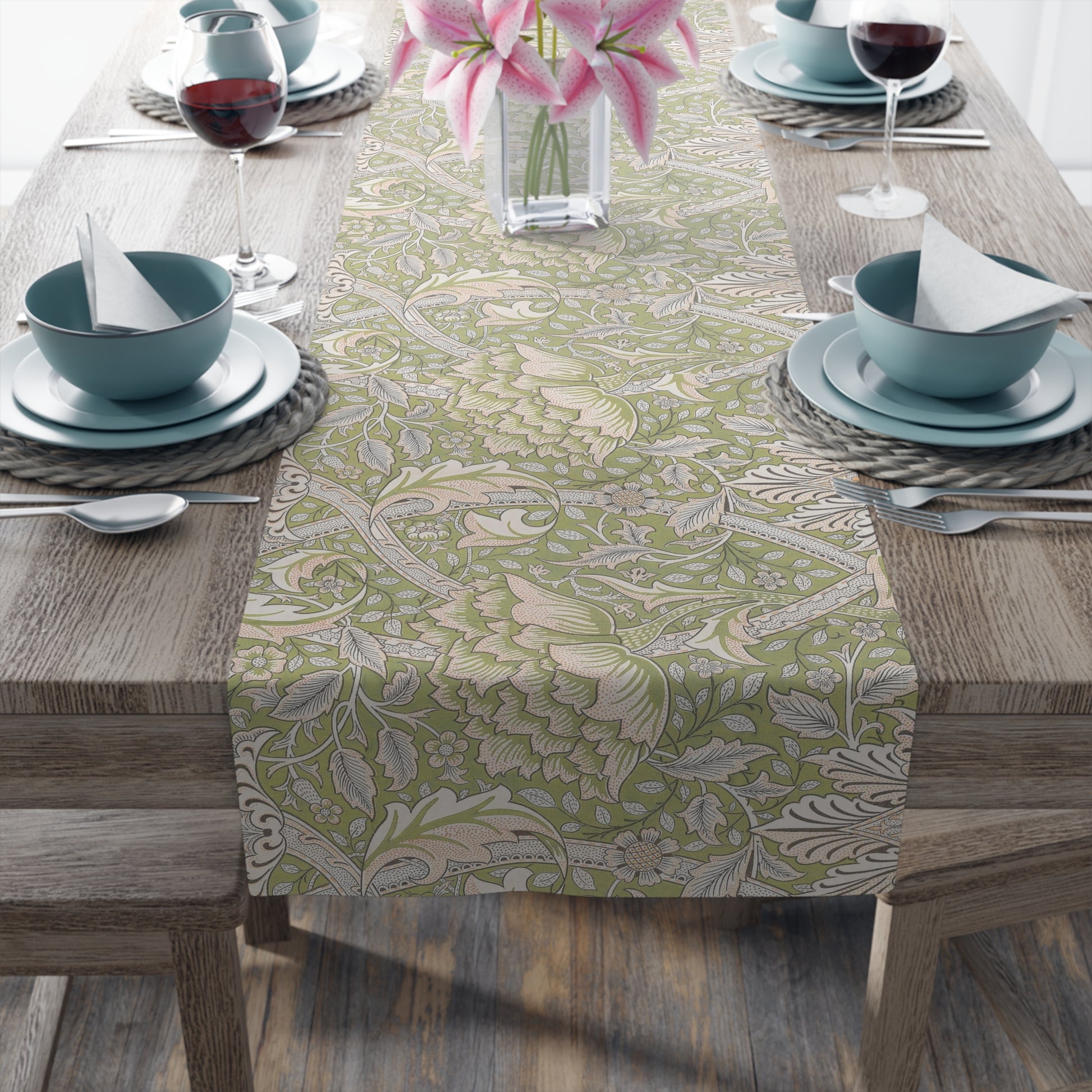 Table setting with a floral patterned table runner on a wooden table.