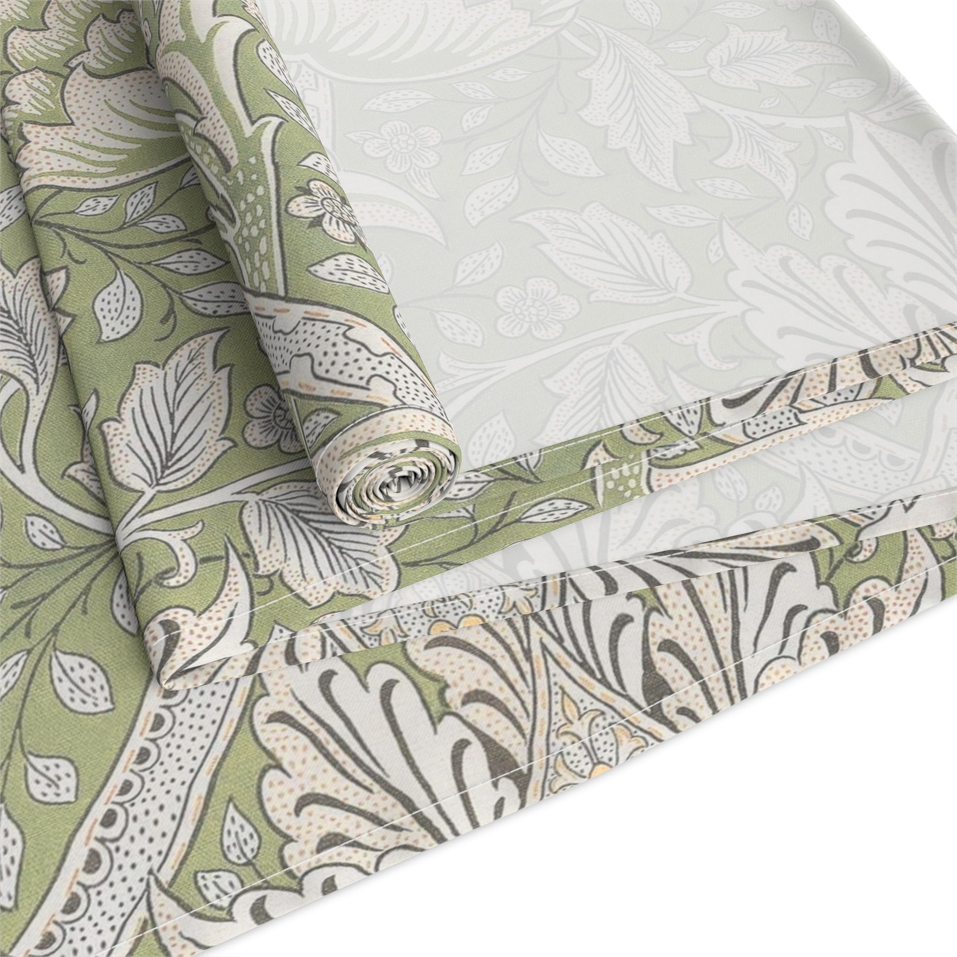 Roll of green and white floral patterned fabric on a white background