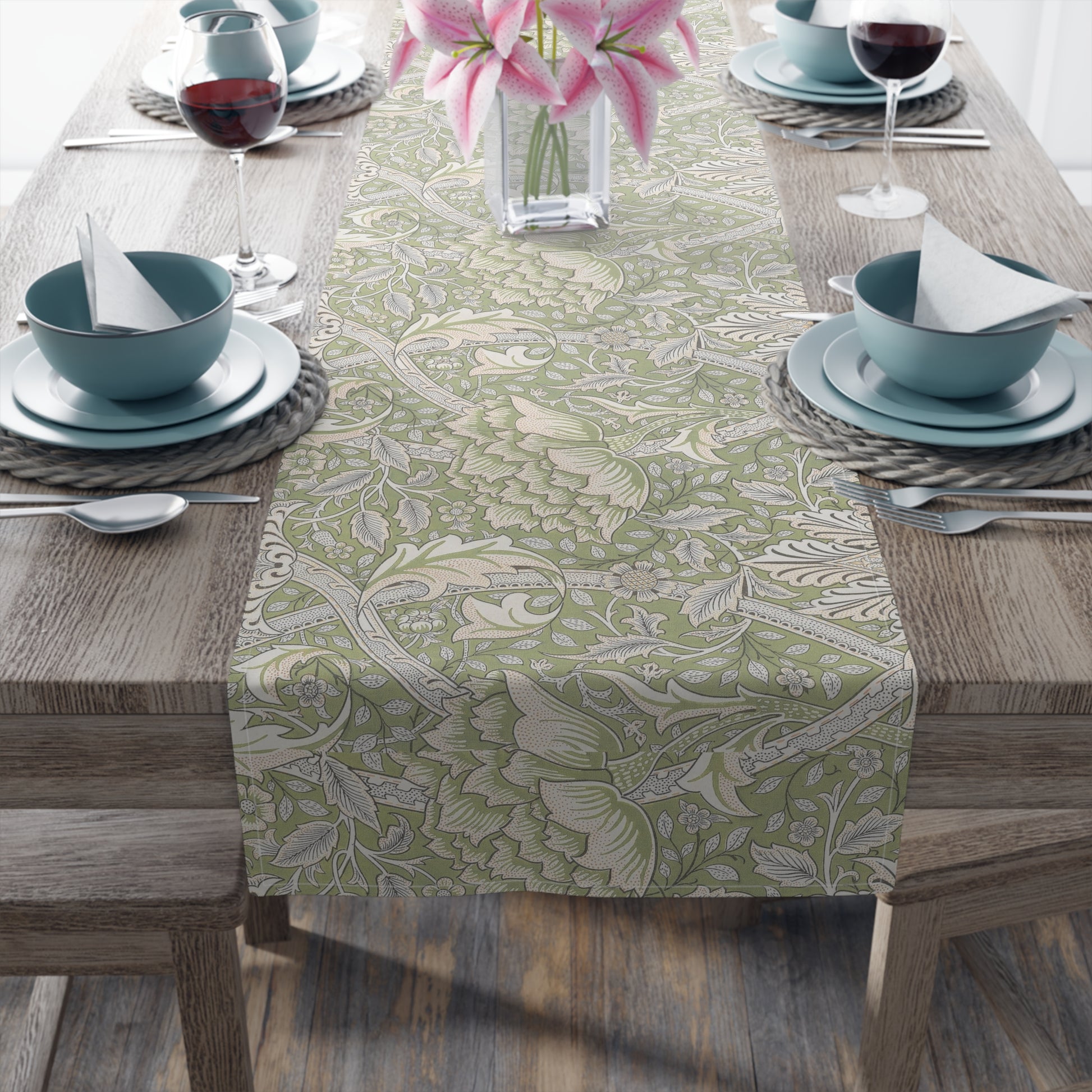 Table setting with a floral patterned table runner on a wooden table.