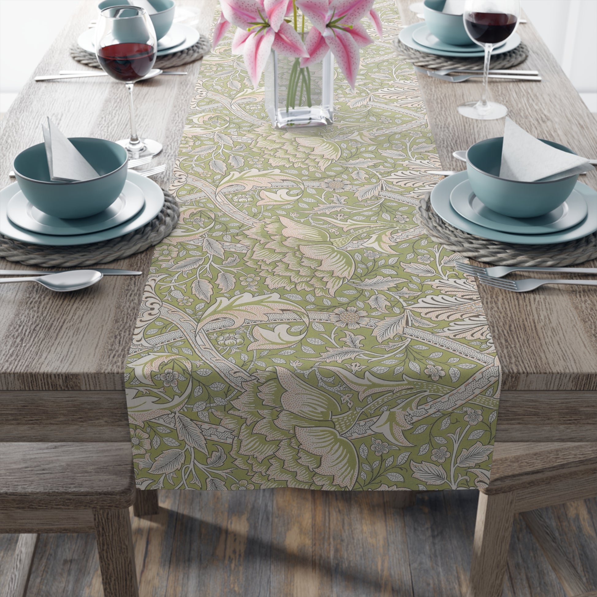 Table setting with a floral patterned table runner on a wooden table.