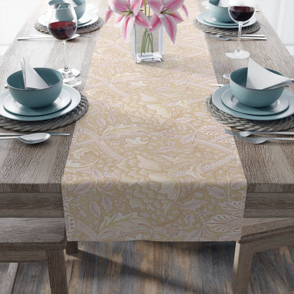 Dining table set with a patterned table runner, blue bowls, and pink flowers.