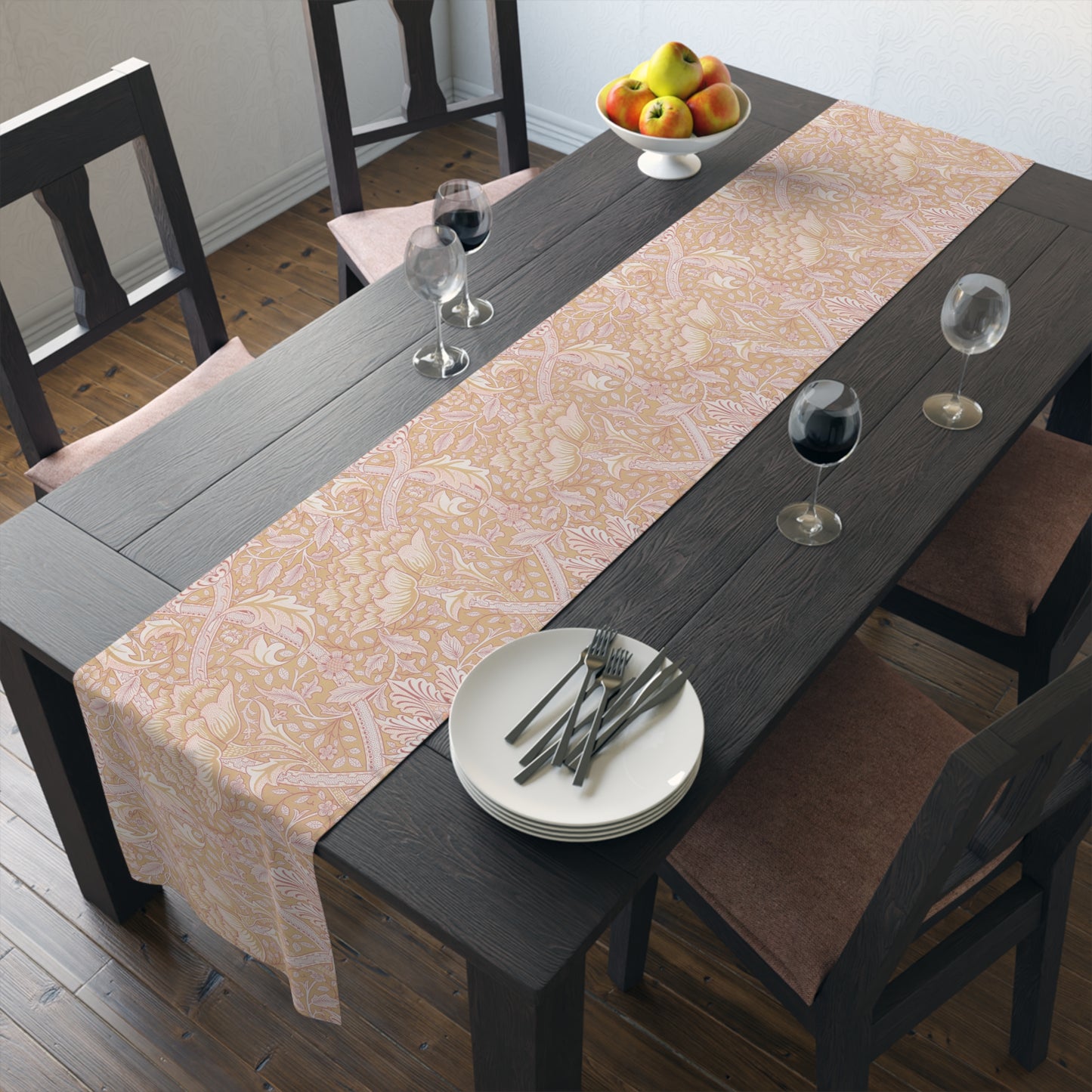 Dining table with a patterned tablecloth, plates, and glasses in a room.