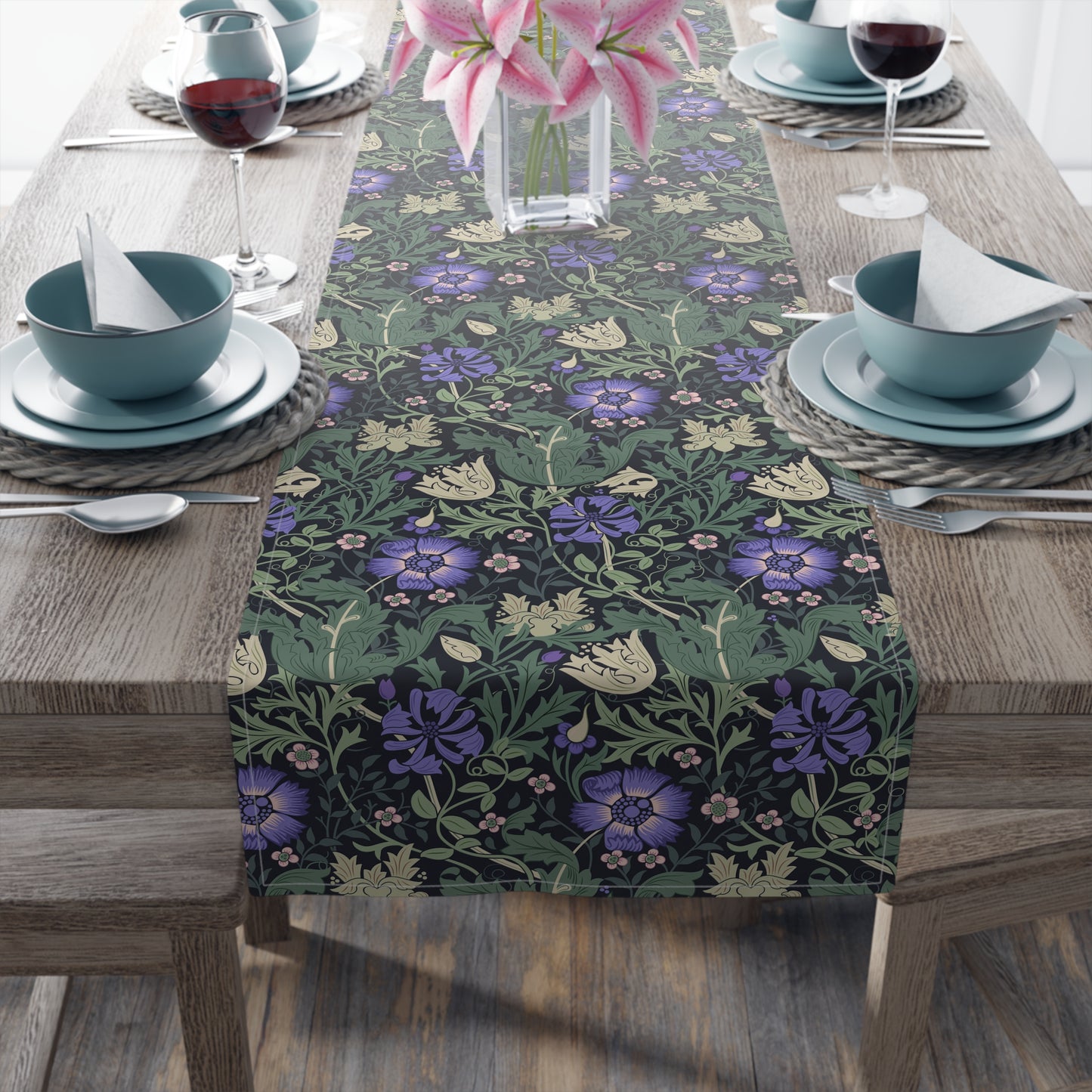 Table setting with a floral patterned table runner on a wooden table.