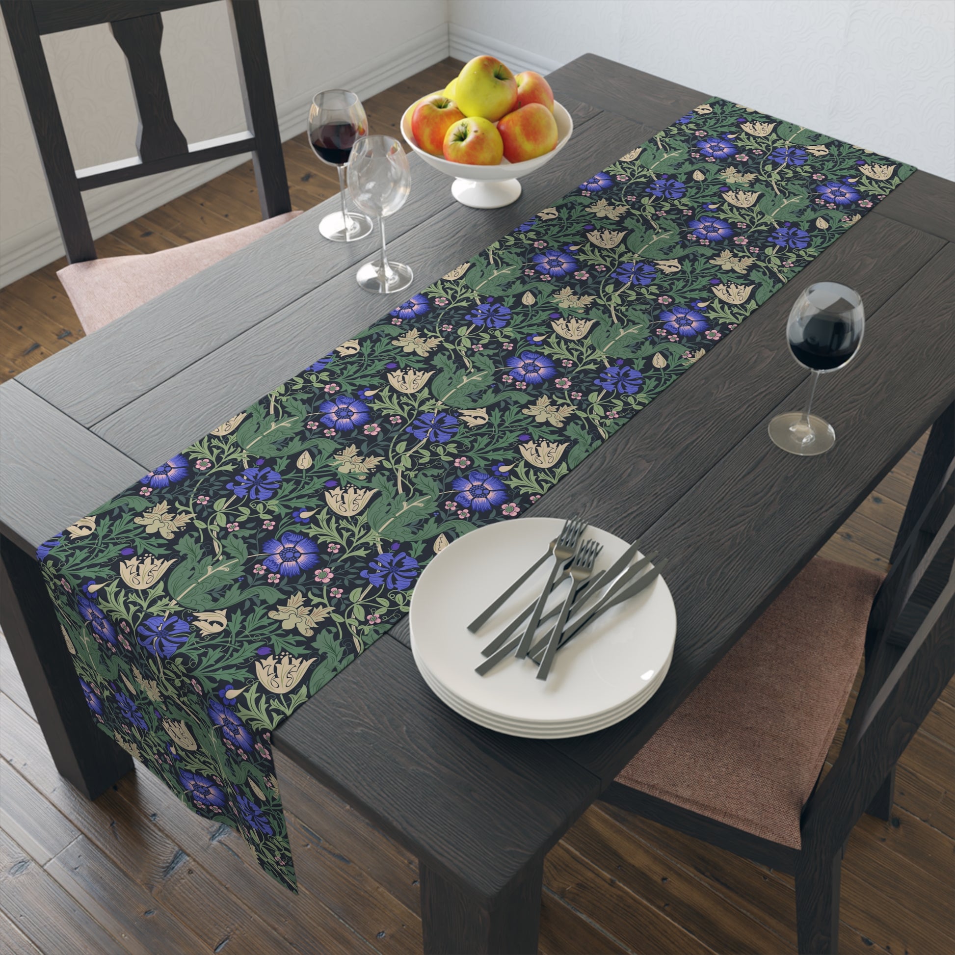 Dining table with a floral table runner, plates, and cutlery.