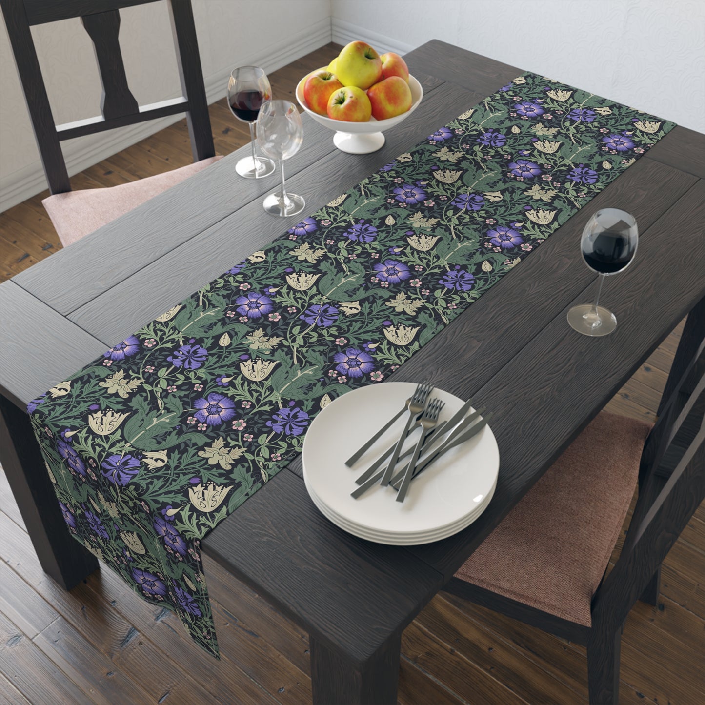Floral patterned table runner on a dining table with plates, cutlery, and fruit.