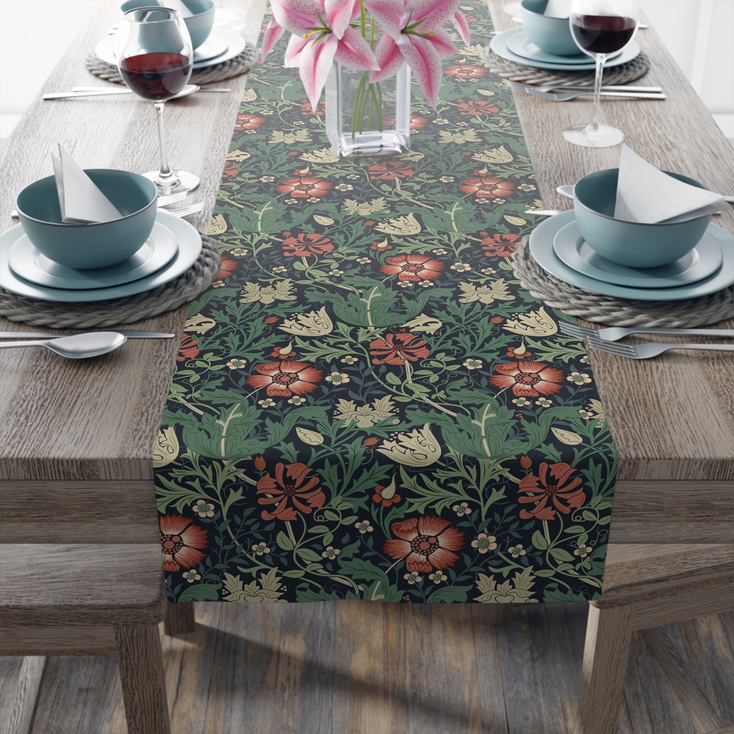 Floral patterned table runner on a wooden table with place settings.