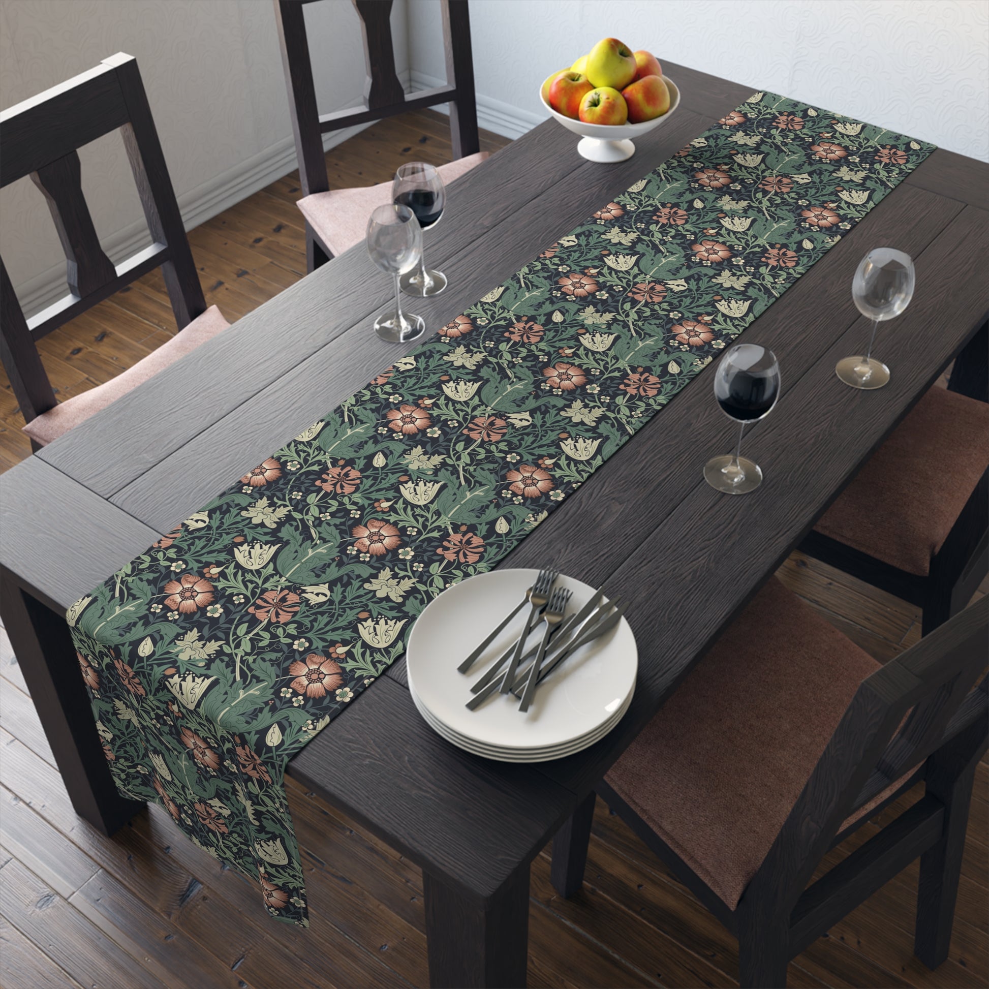 Dining table with floral table runner, plates, and glasses in a room.