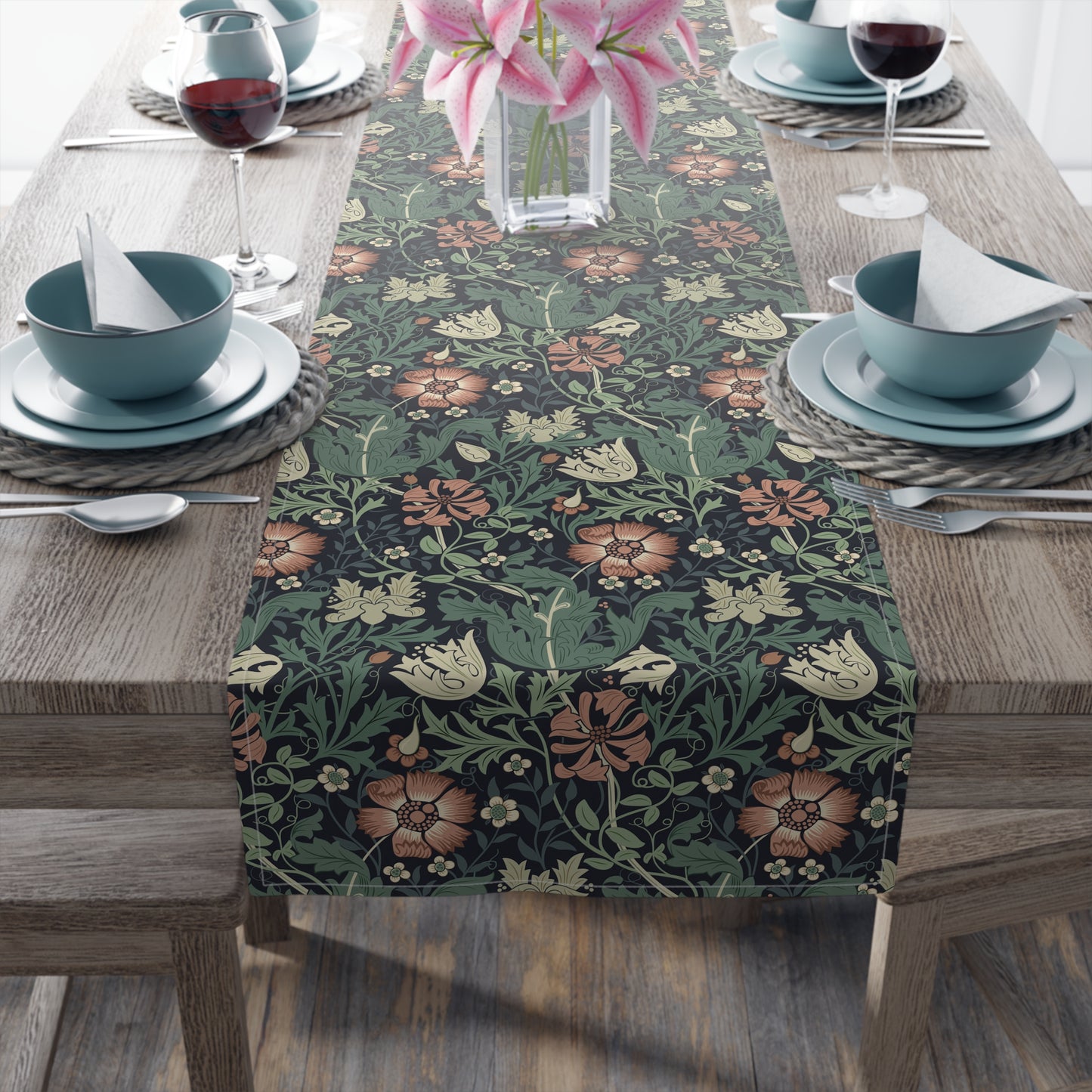 Floral patterned table runner on a wooden table with place settings.