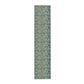 A table runner with a green and gold William Morris & Co pattern displayed on a dining table setting with dishes and glasses.