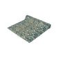 A table runner with a green and gold William Morris & Co pattern displayed on a dining table setting with dishes and glasses.