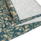A table runner with a green and gold William Morris & Co pattern displayed on a dining table setting with dishes and glasses.