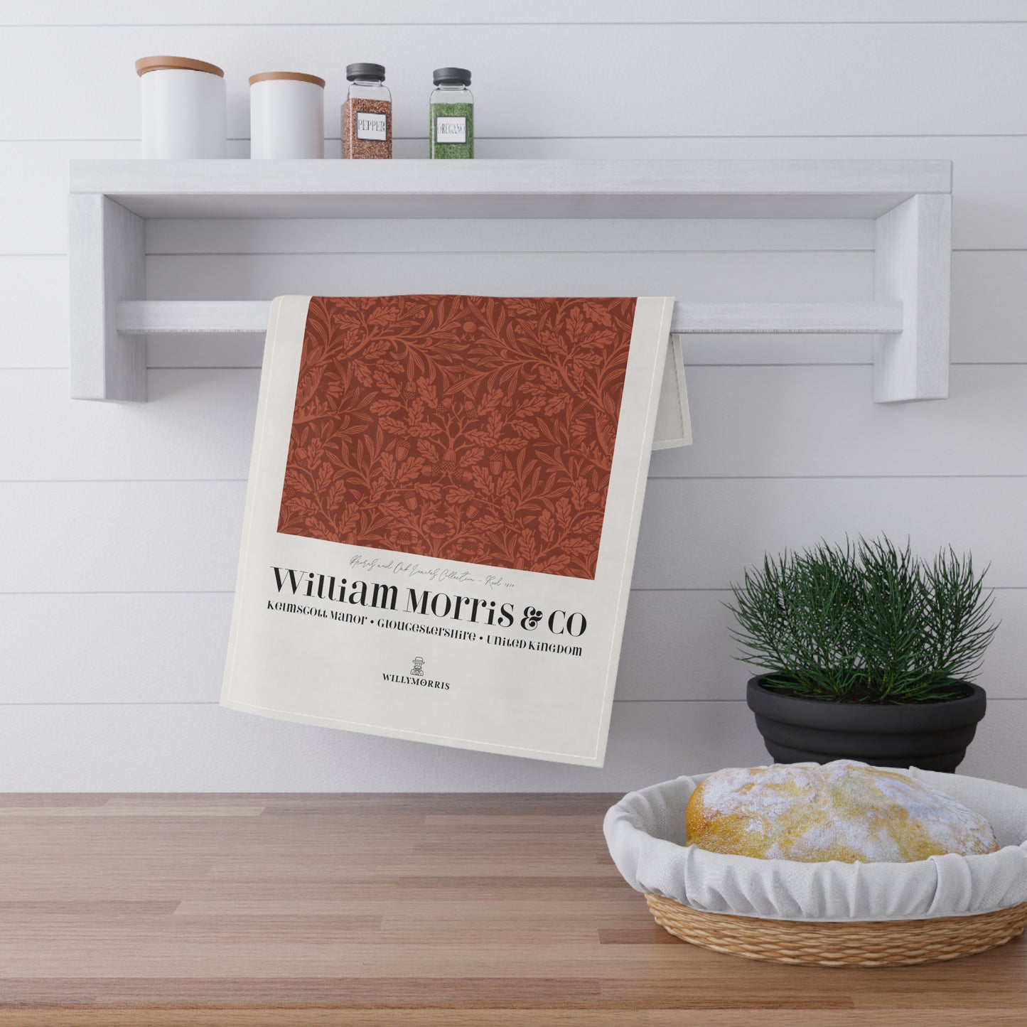 Tea towel with pattern and text hanging on a shelf in a kitchen setting