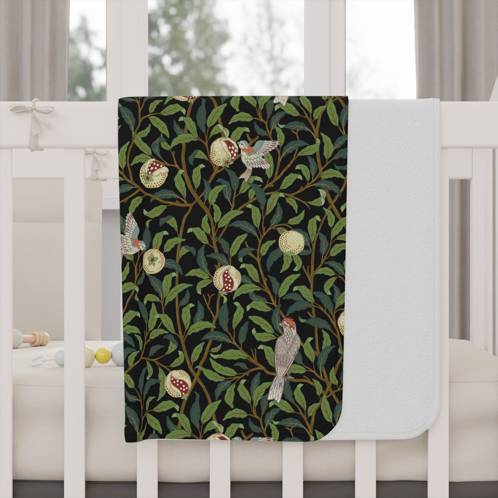 Decorative blanket with nature-themed design on a white crib