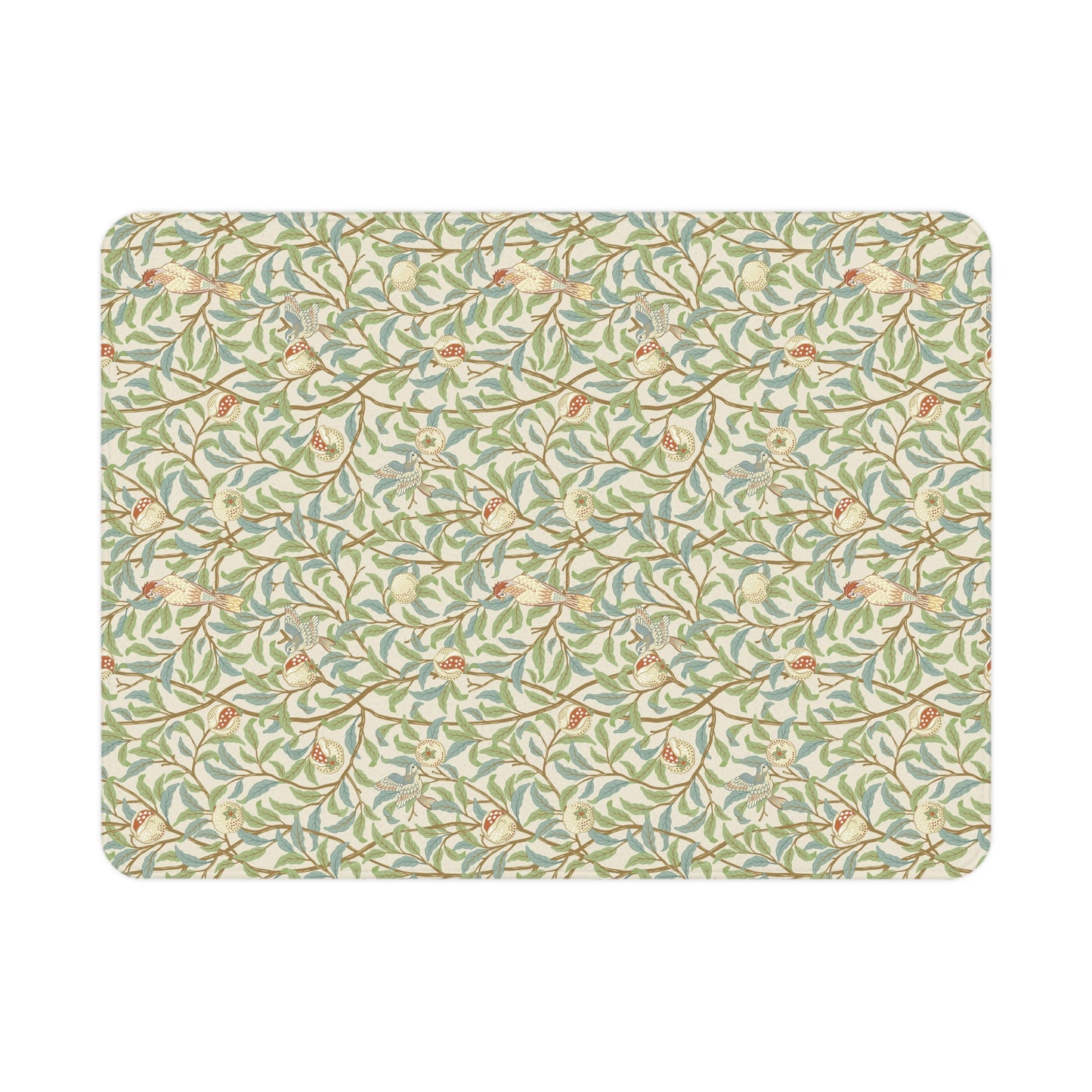 A toddler blanket with a floral pattern featuring birds and pomegranates in green, red, and beige colours on a parchment background.