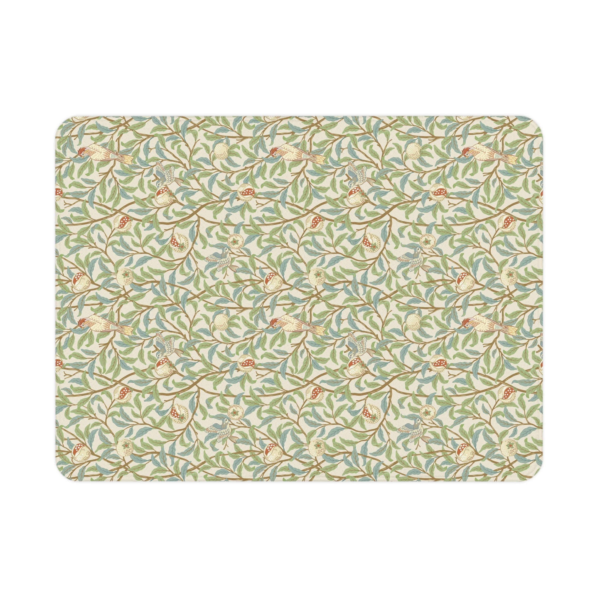 A toddler blanket with a floral pattern featuring birds and pomegranates in green, red, and beige colours on a parchment background.