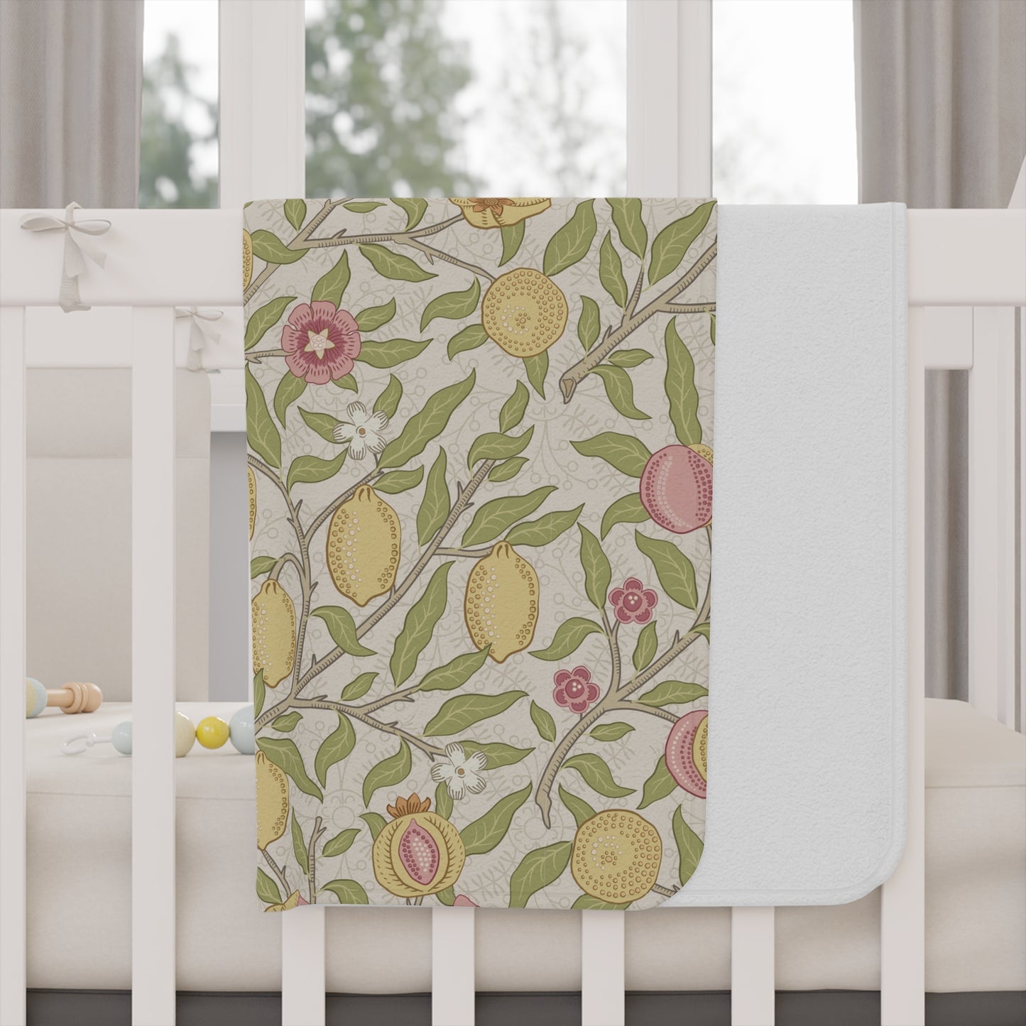 Floral and fruit patterned crib sheet on a white crib