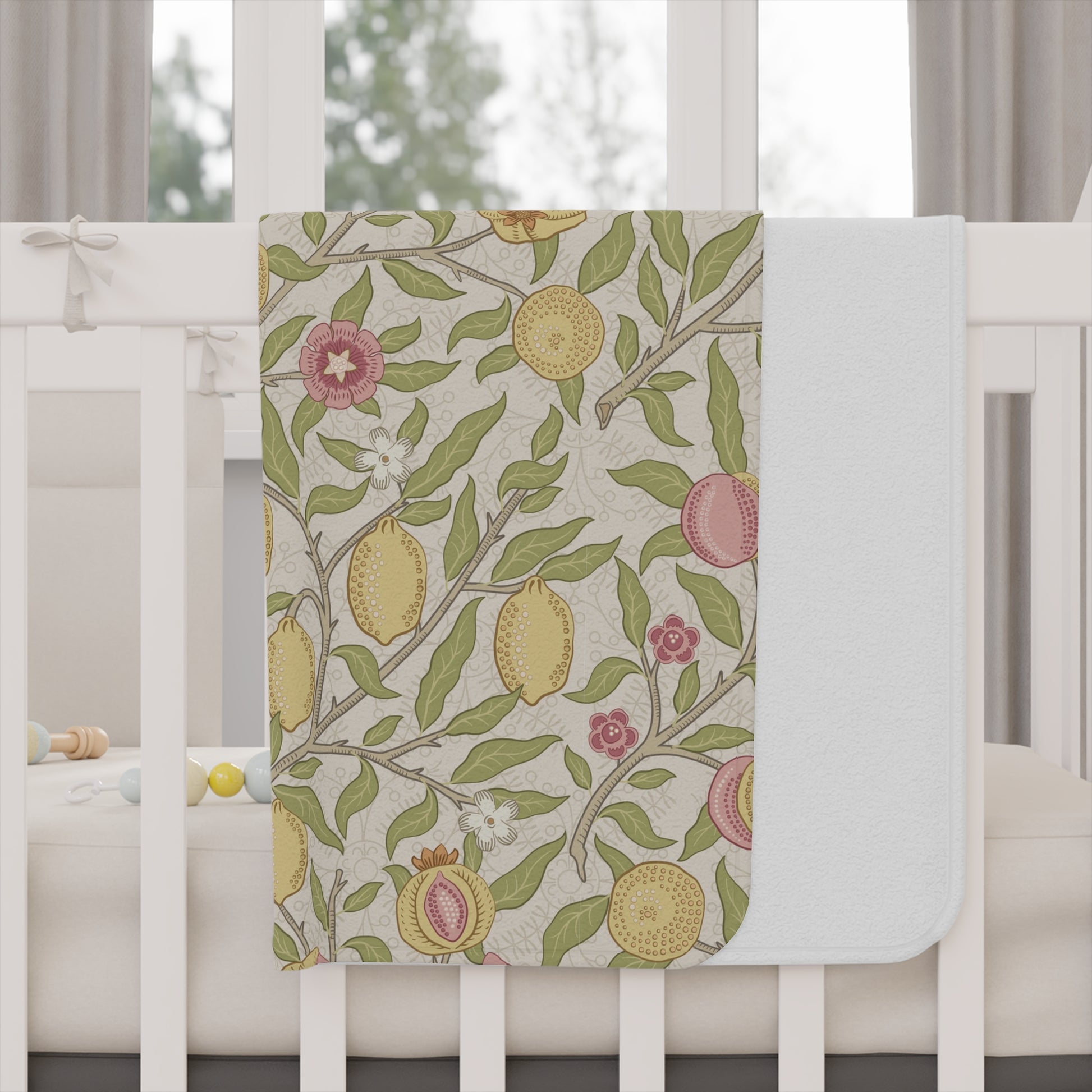 Floral and fruit patterned crib sheet on a white crib
