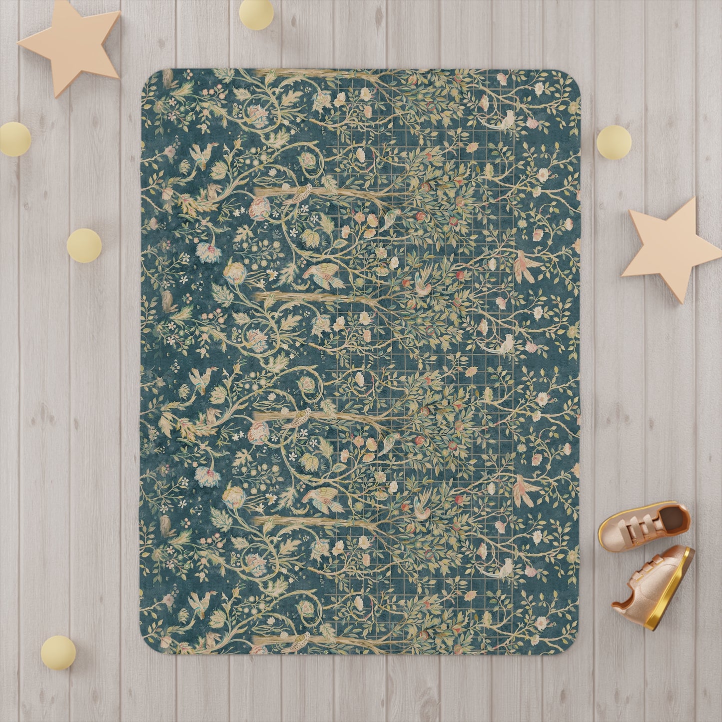 A toddler blanket with a floral William Morris & Co pattern in shades of green, teal, pink, and brown on a white background.