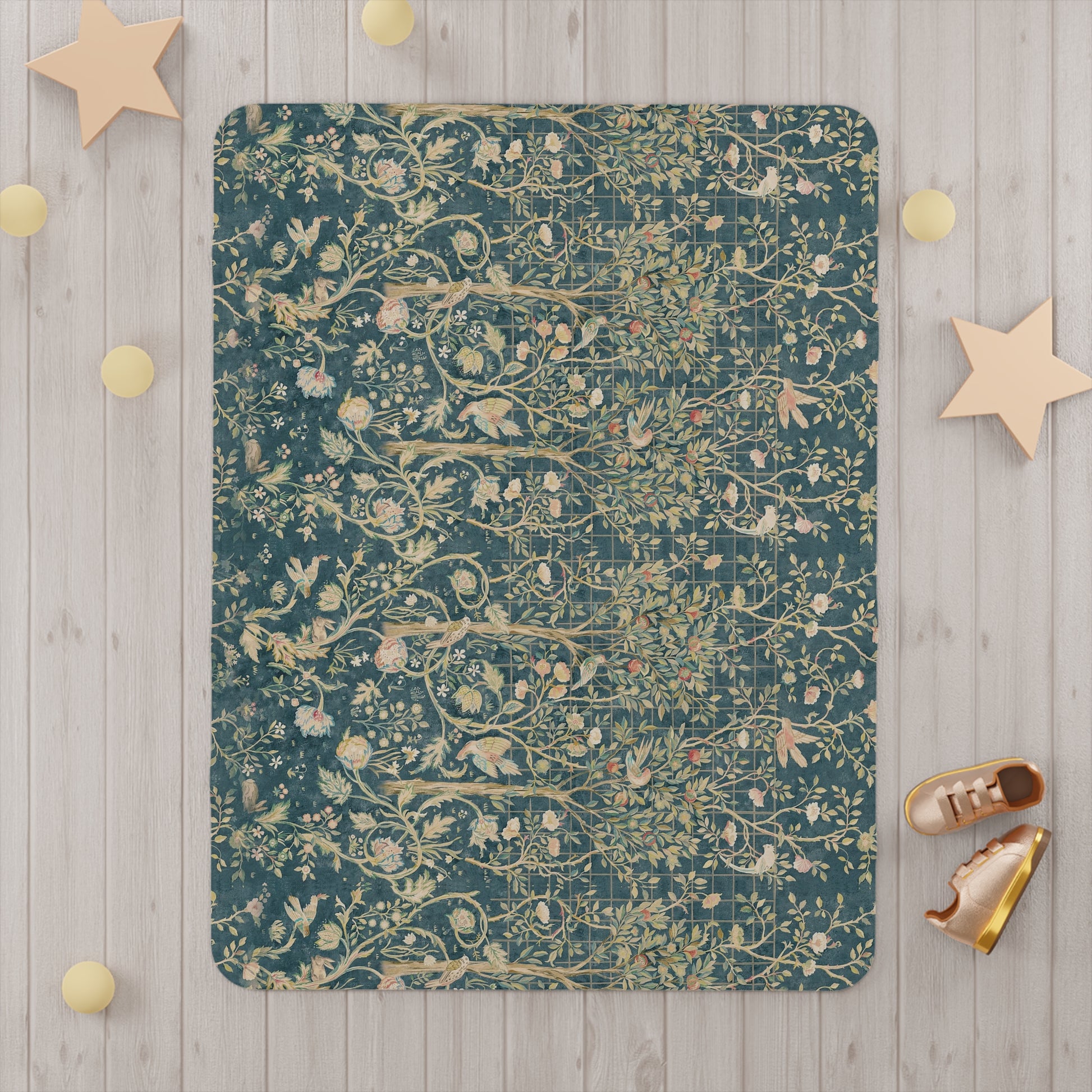 A toddler blanket with a floral William Morris & Co pattern in shades of green, teal, pink, and brown on a white background.