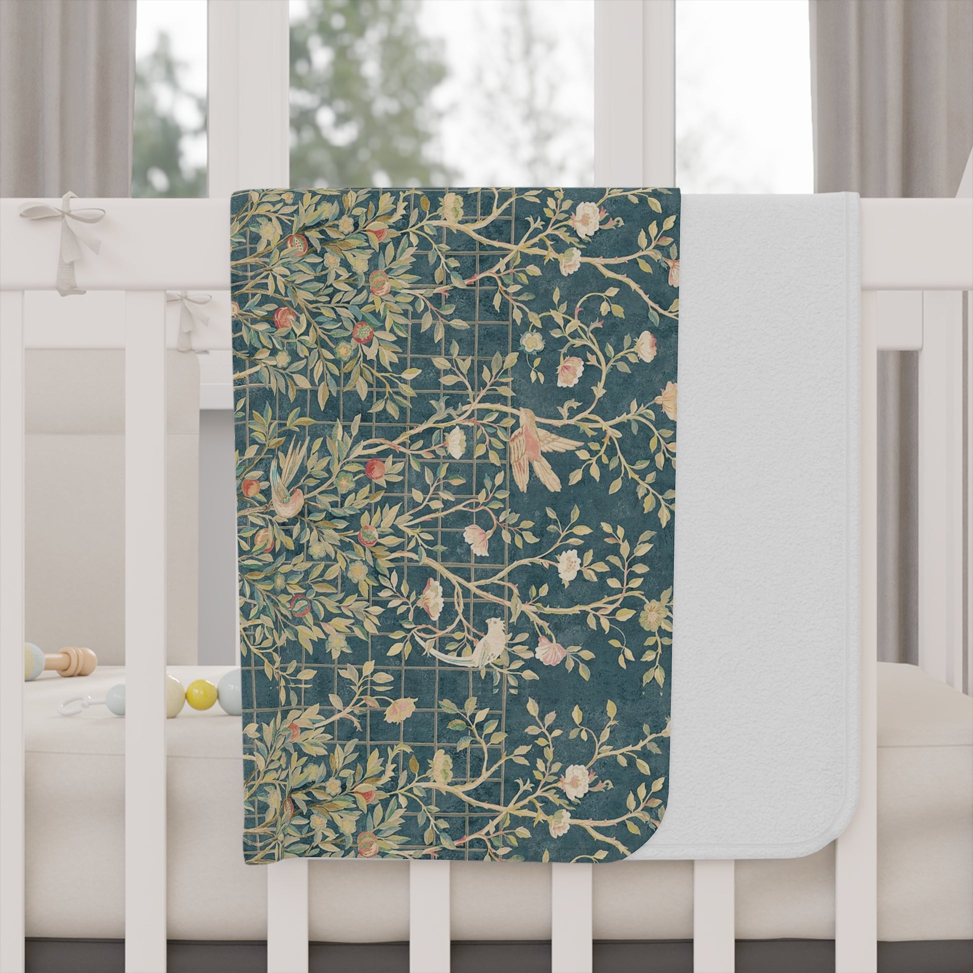 A toddler blanket with a floral William Morris & Co pattern in shades of green, teal, pink, and brown on a white background.