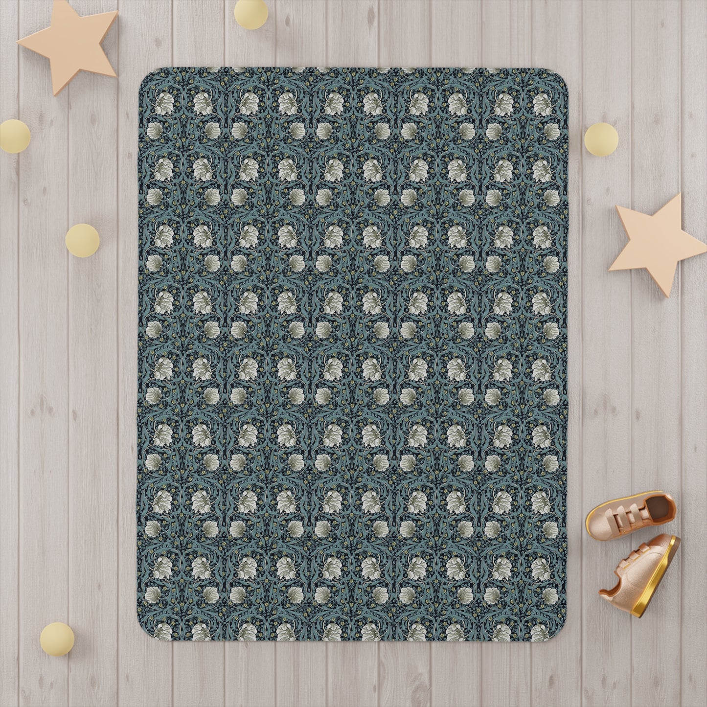 Patterned blanket on a wooden floor with decorative stars and balls.