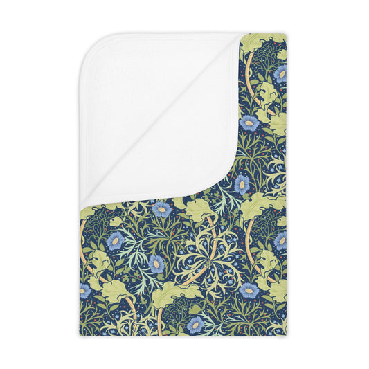 A toddler blanket with a blue and green floral pattern inspired by William Morris' Seaweed Collection.