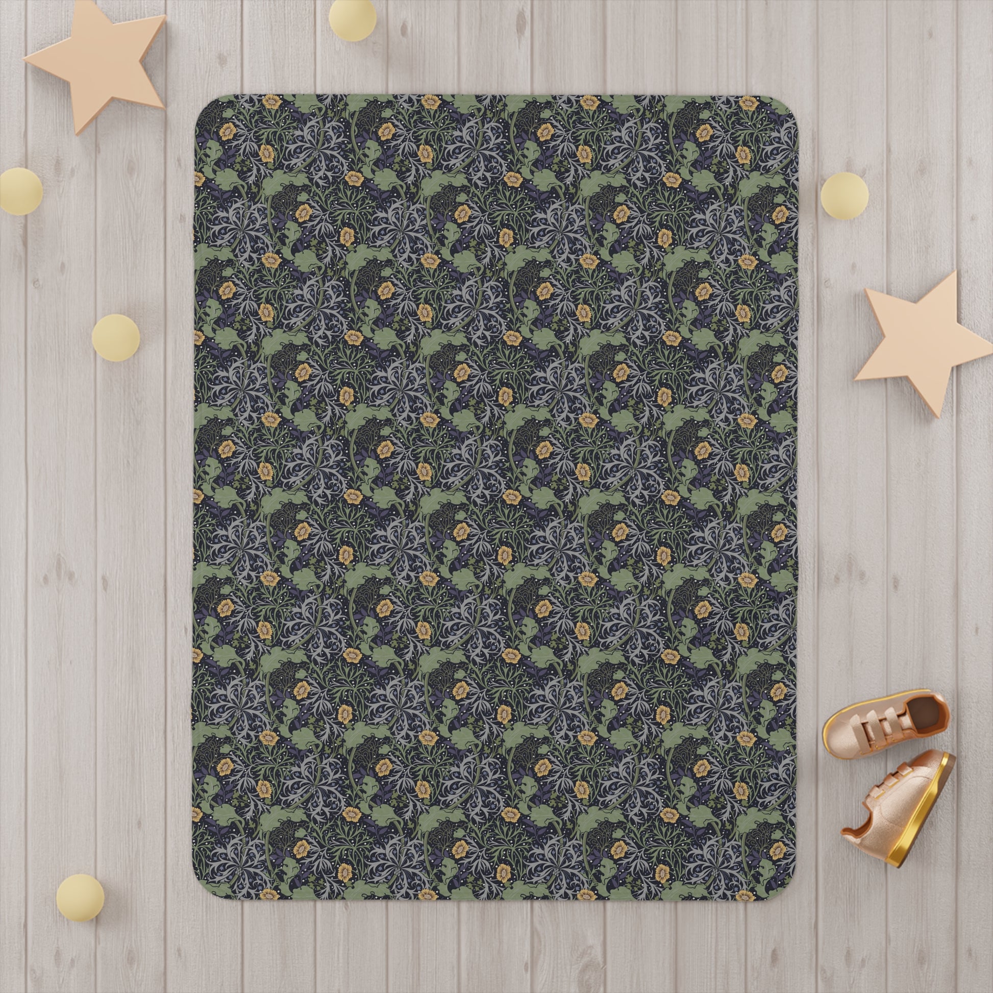 Floral patterned blanket on a wooden floor with decorative stars and shoes around it.