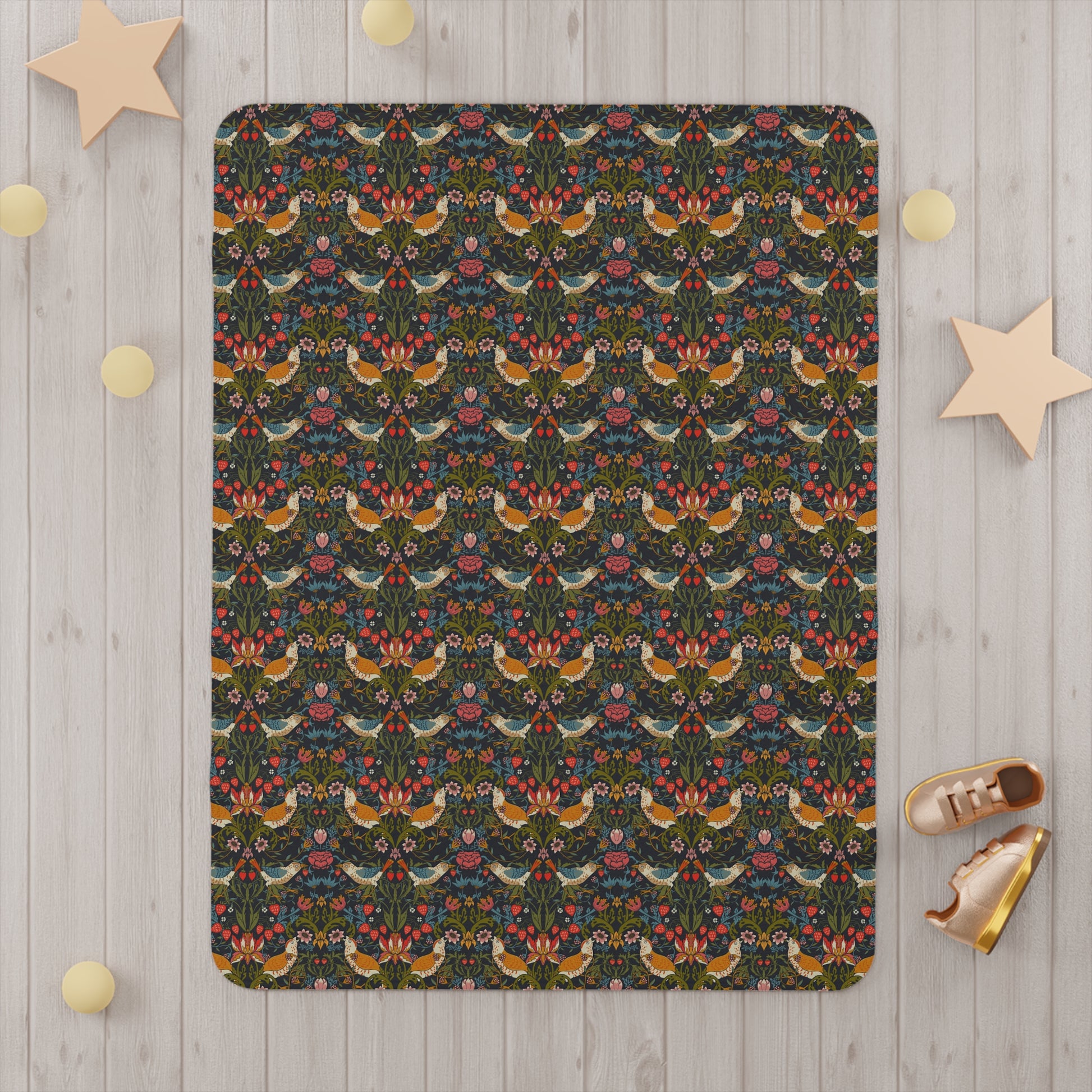 Patterned blanket on a wooden floor with decorative stars and shoes around it.