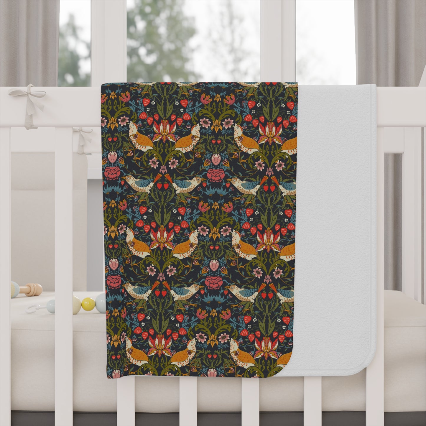 Decorative blanket with floral and bird pattern draped over a white crib.