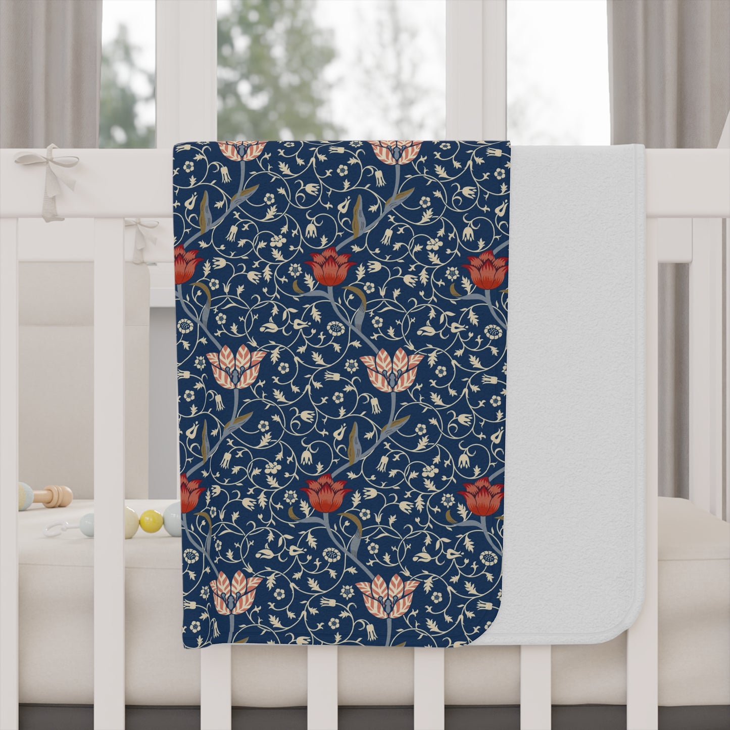 Floral William Morris & Co patterned toddler blanket with red flowers and white leaves on a blue background