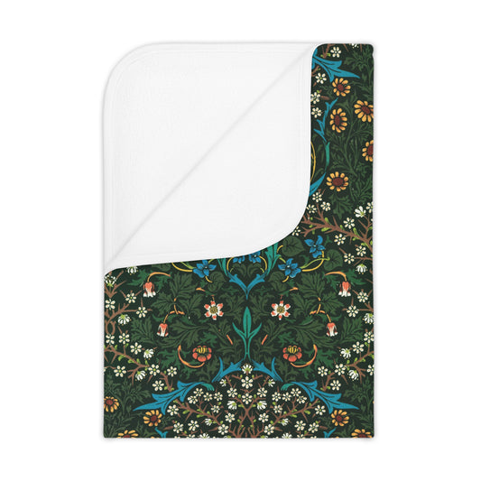 A toddler blanket with a floral pattern inspired by William Morris, predominantly red and green colours, displayed on a white background.