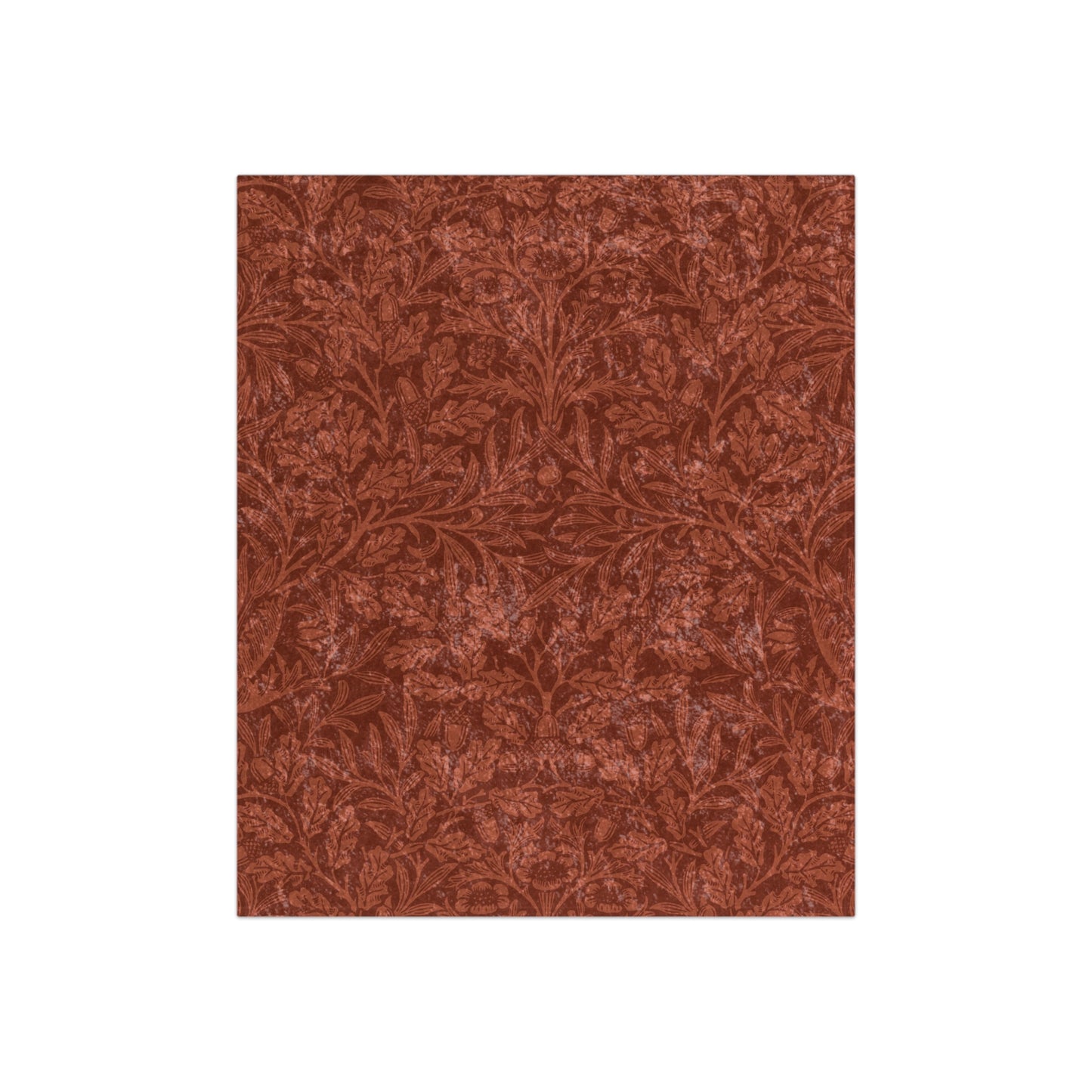 A crushed velvet blanket in a rust colour, with a pattern inspired by William Morris' acorns and oak leaves, displayed folded with the reverse side partially visible.