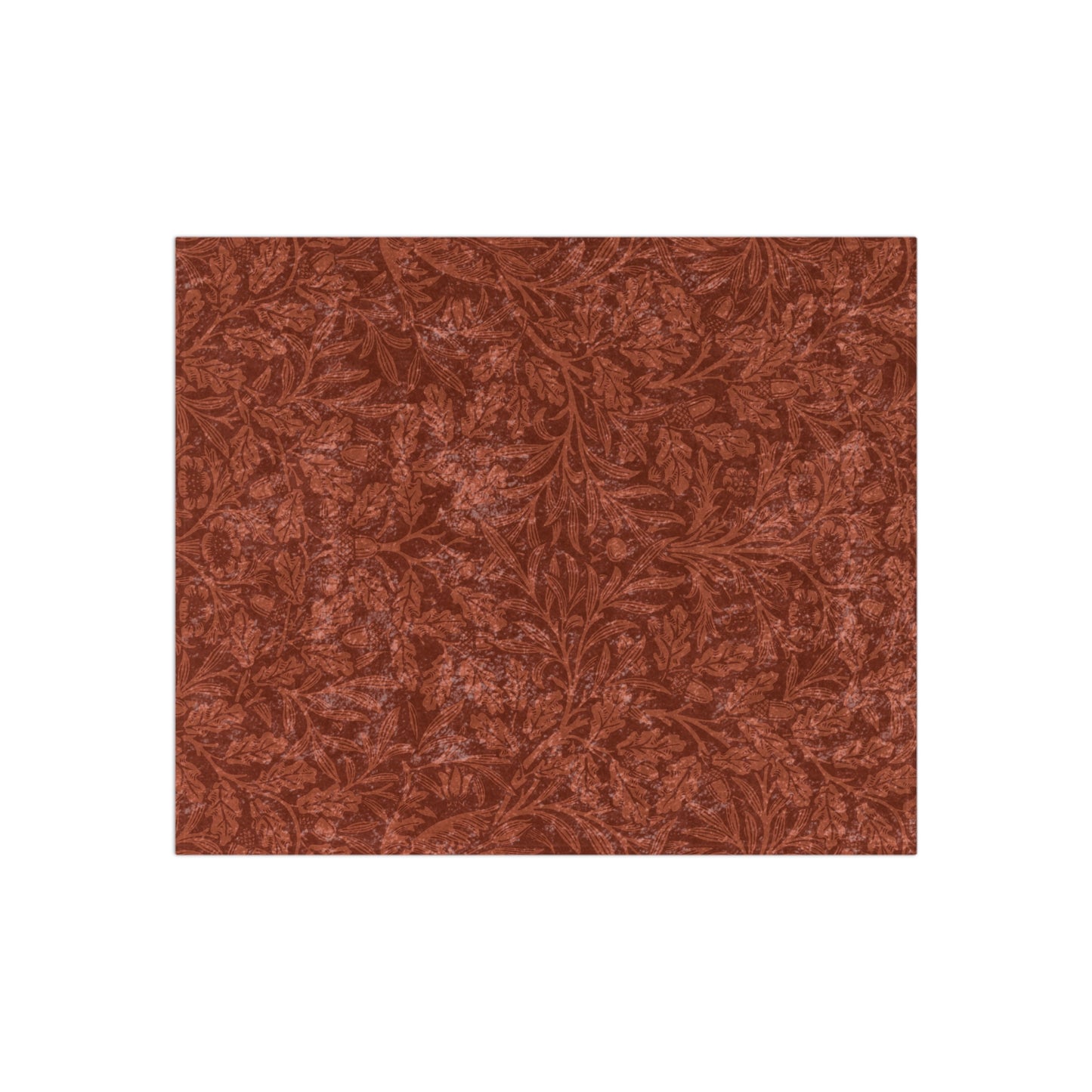 A crushed velvet blanket in a rust colour, with a pattern inspired by William Morris' acorns and oak leaves, displayed folded with the reverse side partially visible.
