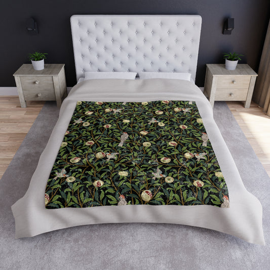A plush velvet blanket with a one-sided print featuring a bird and pomegranate design on a dark background, with hemmed edges and a silky finish.
