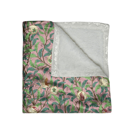A plush, floral patterned velvet blanket with hemmed edges, inspired by William Morris' Bird & Pomegranate Collection.