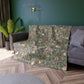 A plush, floral patterned velvet blanket with hemmed edges, inspired by William Morris' Bird & Pomegranate Collection.